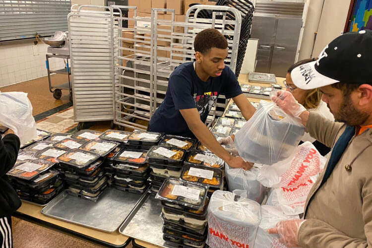 Volunteer helps pack meals for seniors at Encore Community Center