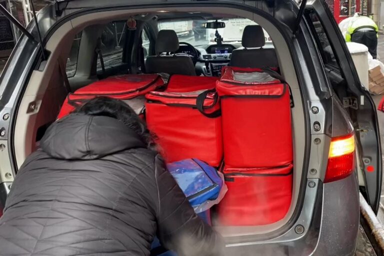 Encore workers load a van with meals to deliver