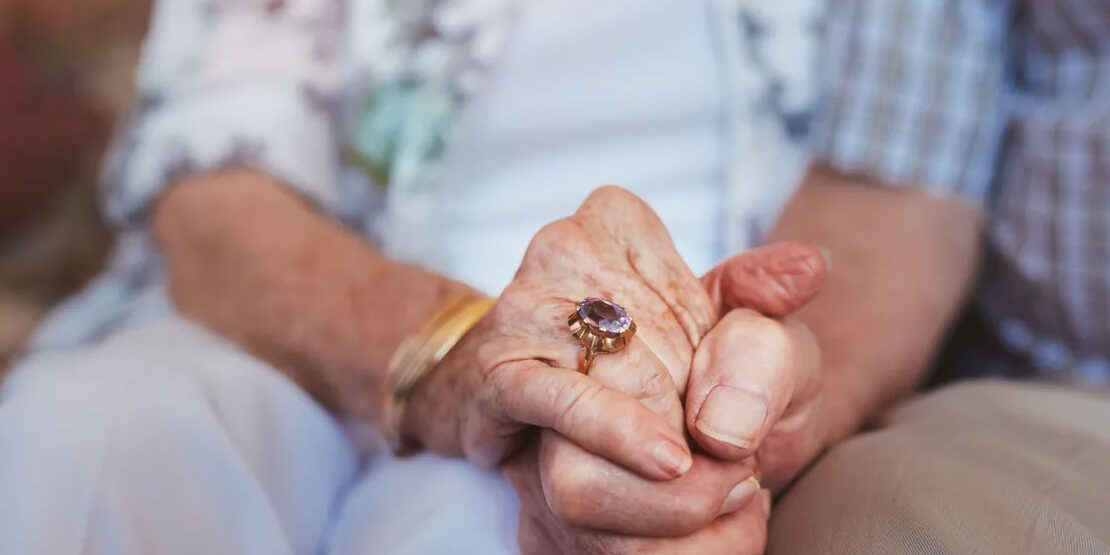 Elderly couple holding hands